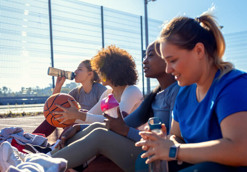 diverse-group-of-young-woman-sitting-on-court